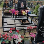 Памятник с крестом, ограда и цветы — фото 1