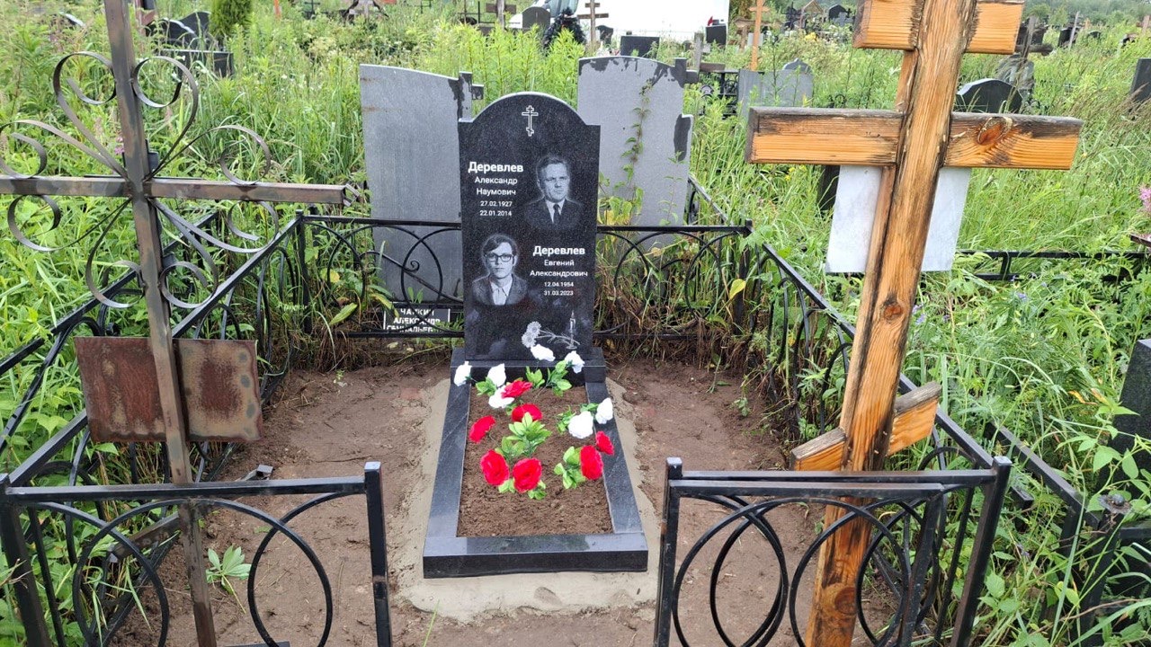 Памятник с крестом и кованой оградой