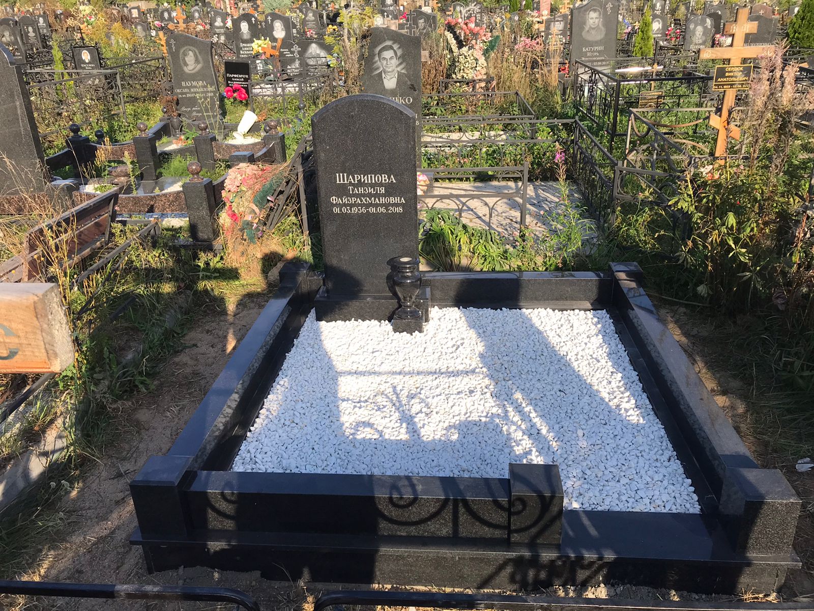 Благоустройство с чёрным памятником и крошкой